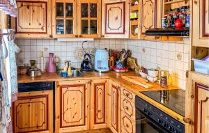 a kitchen with wooden cabinets and a counter top at Cozy Home In Rrvik With Wi-fi in Rørvik
