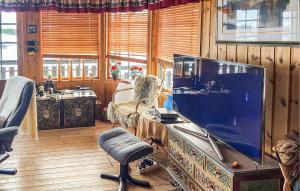 Cozy Home In Rrvik With Wi-fi في Rørvik: امرأة جالسة في غرفة معيشة مع تلفزيون كبير
