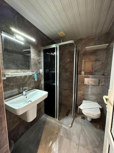 a bathroom with a sink and a shower and a toilet at HAVANA HOTEL in Kemer