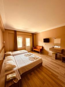Un dormitorio con una cama grande y una silla. en HAVANA HOTEL, en Kemer