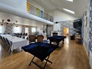 a dining room with a table and chairs and a fireplace at Šubrakkrasti in Vestiena