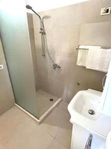 uma casa de banho com um chuveiro e um lavatório. em Hotel Algo em Tirana