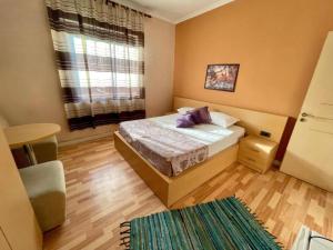 um pequeno quarto com uma cama e uma janela em Hotel Algo em Tirana