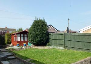 a yard with a fence and a house at Port View House in Cardiff