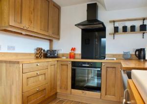 cocina con armarios de madera y horno en Port View House en Cardiff