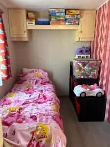 a childs bedroom with a bed with pink sheets at Stacaravan aan de Maas in Op-Andel