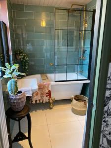 a bathroom with a tub and a glass shower at Luxurious quirky 2bedroom house in Southampton
