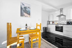 Il comprend une petite cuisine avec une table et des chaises en bois. dans l'établissement Stylish New Apartment - Free Wifi & Netflix - 3MH, à Old Hill