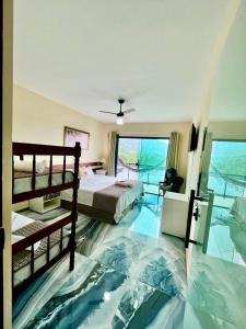 a bedroom with a bed and a view of the ocean at POUSADA OHANA PARATY in Paraty