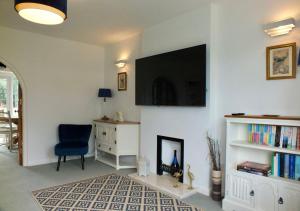 uma sala de estar com uma cadeira e uma televisão na parede em Port View House em Cardiff