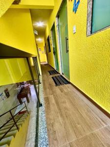 einen leeren Flur eines Gebäudes mit gelber Wand in der Unterkunft POUSADA OHANA PARATY in Paraty