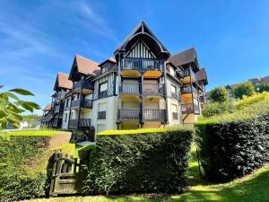 un gran edificio con arbustos delante de él en Balcon sur Sea, Sun and Horses, en Deauville