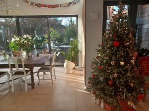 Un árbol de Navidad en un comedor con mesa en Pound Orchard Bed and Breakfast, en Petersfield
