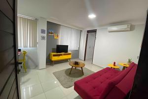 uma sala de estar com um sofá vermelho e uma mesa em 10ª Pirâmide Manaíra by Allmare Apartamentos em João Pessoa