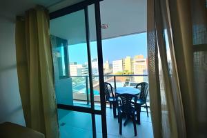 a balcony with a table and chairs and a view of the city at Atlantis Cabo Branco by Allmare Temporada in João Pessoa