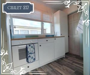 a kitchen with white cabinets and a window at THE CHALETS 217 & 289 in Withernsea
