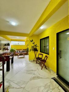 POUSADA OHANA PARATY في باراتي: غرفة معيشة مع طاولة بلياردو وجدران صفراء