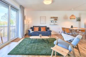 sala de estar con sofá azul y mesa en Sonnenflut, en Haffkrug