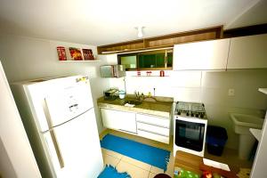 a kitchen with a white refrigerator and a stove at Luxor Paulo Miranda 409 by Allmare Apartamentos in João Pessoa