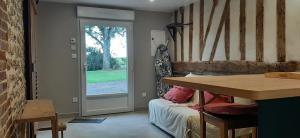 Habitación con mesa y puerta con ventana en Le Thuit - F2 Plain pied tout équipé à la ferme, en Charleval