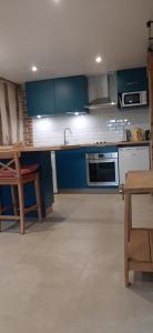 a kitchen with blue cabinets and a sink at Le Thuit - F2 Plain pied tout équipé à la ferme in Charleval +9 photos