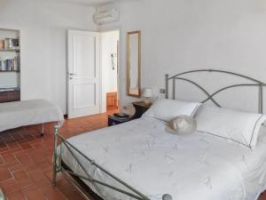 een slaapkamer met een wit bed met een metalen frame bij * Apartment in Barga Old Town with amazing views in Barga