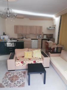 uma sala de estar com um sofá e uma cozinha em Darna em El Haouaria