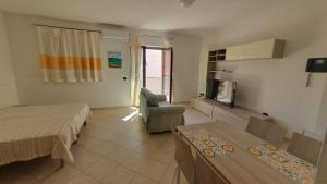 a bedroom with a bed and a chair and a television at Monolocale in centro con parcheggio privato! in Palau