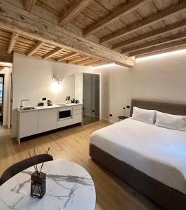 a bedroom with a large bed and a kitchen at La Dimora del Brocante in Cuneo