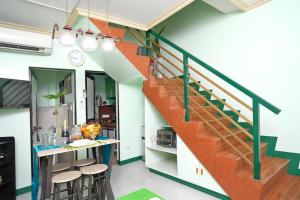 a kitchen with a staircase and stools in a room at Golden V Primera Unit A in Malolos