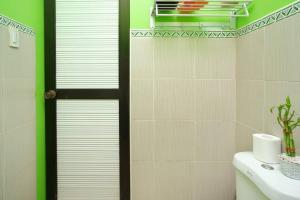 a bathroom with a white toilet and a green wall at Golden V Primera Unit A in Malolos