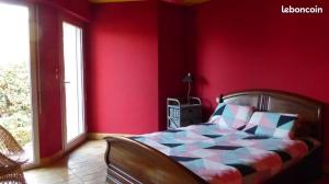 - une chambre dotée d'un lit avec un mur rouge dans l'établissement La palette - Maison vue sur mer, à Saint-Gildas-de-Rhuys