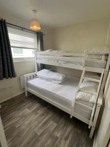 a bedroom with two bunk beds and a window at 192, Two bed newly refurbished chalet on Sund0wner Holiday Park - Sleeps 5, pet friendly - Includes electricity, bed linen and towels - Entertainment options close by in Hemsby