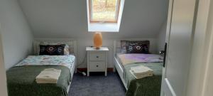 2 Einzelbetten in einem kleinen Zimmer mit Fenster in der Unterkunft Apartament Sadyba in Świeradów-Zdrój