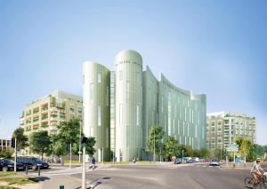 a large white building with people riding bikes on a street at All Suites Appart Hôtel - Noisy-le-Grand in Noisy-le-Grand