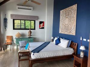 1 dormitorio con 1 cama con pared azul en Stunning seaview, Gorgeous Villa of architect 4br, en Ko Pha Ngan