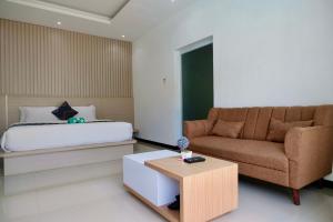 1 dormitorio con cama, sofá y mesa en Daniswara Villa en Uluwatu