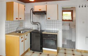 a kitchen with a black stove and a sink at Stunning Home In Untertilliach With 2 Bedrooms And Wifi in Untertilliach