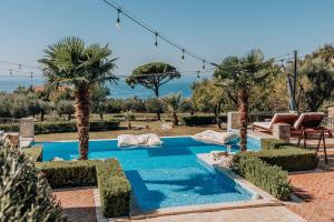 a swimming pool in a yard with palm trees at Talići Hill - Rustic Villas in Sutomore