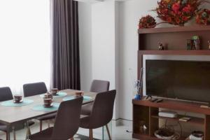 a dining room with a table with chairs and a television at New Apartment in Historic City Center in Cusco