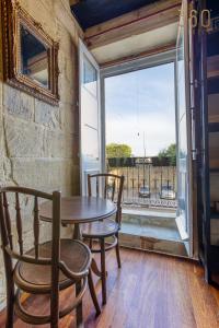 comedor con mesa, sillas y ventana en Charming home with Stunning City Views in Birgu by 360 Estates, en Birgu