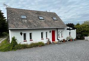 a white house with a red door at Barn Owl Cottage, The Welsh Reindeer Retreat, Ystradfach Farm , Llandyfaelog, Carmarthen , SA17 5NY in Carmarthen
