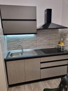 a kitchen with a sink and a stove at Taormina Roby Casa Vacanze in Giardini Naxos
