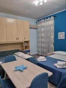 a room with two tables and two blue chairs at Taormina Roby Casa Vacanze in Giardini Naxos