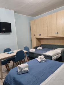 a room with two beds and a table and cabinets at Taormina Roby Casa Vacanze in Giardini Naxos +23 photos