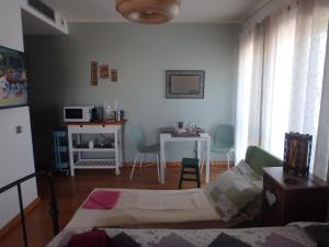 a living room with a bed and a table at Suite na Casa da Andreia in São Martinho do Porto