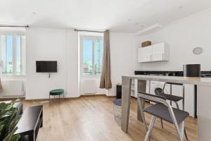 uma sala de estar branca com uma mesa e cadeiras em La Pépite de la Joliette - Central & Lumineux - Les Frères de la Loc' em Marselha