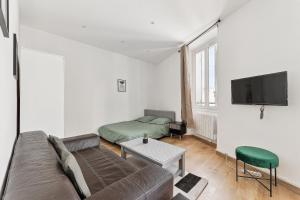 uma sala de estar com um sofá e uma cama em La Pépite de la Joliette - Central & Lumineux - Les Frères de la Loc' em Marselha