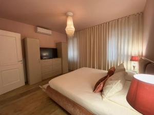 - une chambre avec un lit blanc et une télévision dans l'établissement MURANO Place - MISTRO House, à Murano