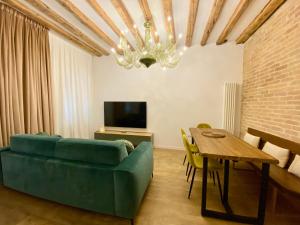 a living room with a green couch and a table at MURANO Place - MISTRO House in Murano